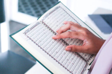 Close up of hand when reading the Holy Quran at the mosque. Selective focus.